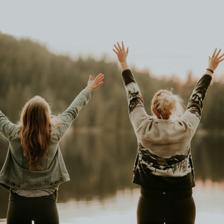 Zwei Frauen heben die Arme in der Natur – Mental Coaching für mehr Lebensfreude und mentale Stärke
